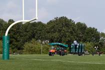 New York Jets personnel clear practice equipment after practice was canceled at the NFL footbal ...