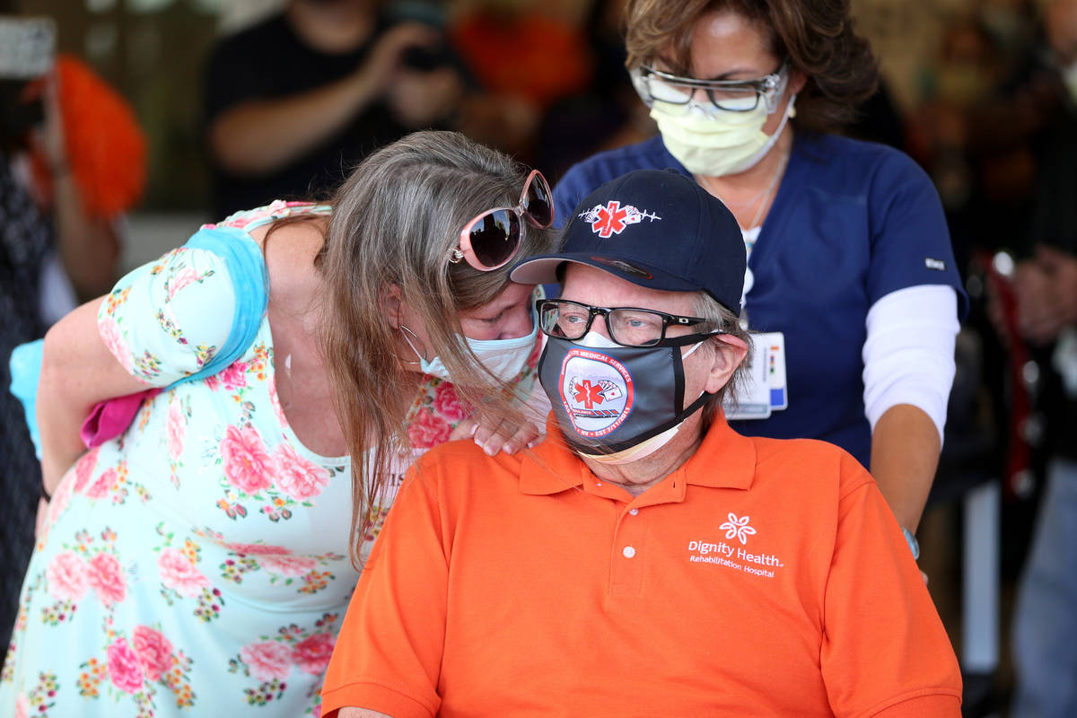 Paramedic John Foster, center, a recovered COVID-19 patient, with his girlfriend Laurie Matthew ...