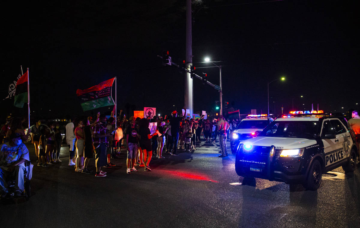 People stop traffic as police look on during a rally against police brutality by the Martin Lut ...