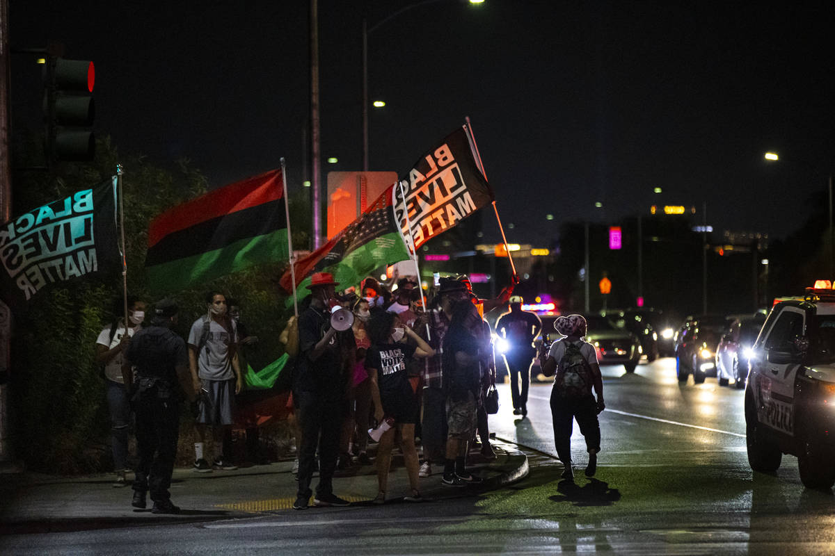 People march during a rally against police brutality by the Martin Luther King Jr. statue in No ...