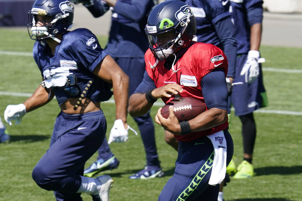 Seattle Seahawks quarterback Russell Wilson runs with a ball Sunday, Aug. 30, 2020, during an N ...