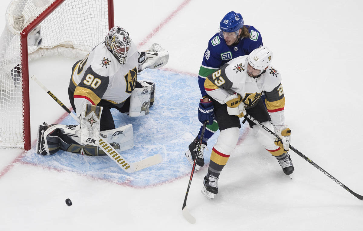 Vegas Golden Knights goaltender Robin Lehner (90) makes a save as Vancouver Canucks center Adam ...