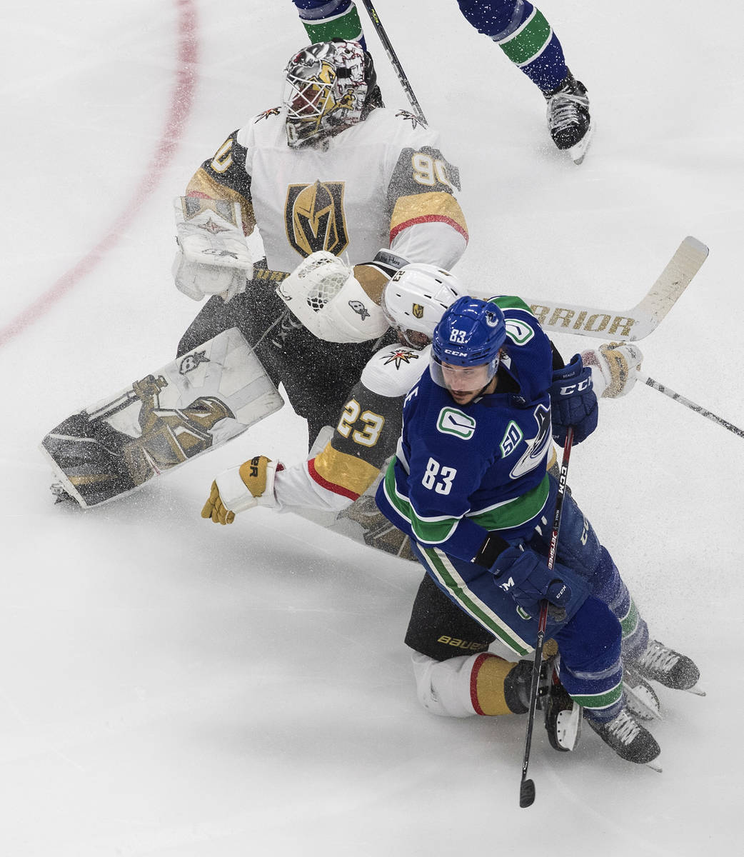 Vegas Golden Knights goalie Robin Lehner (90) looks for the puck as teammate Alec Martinez (23) ...