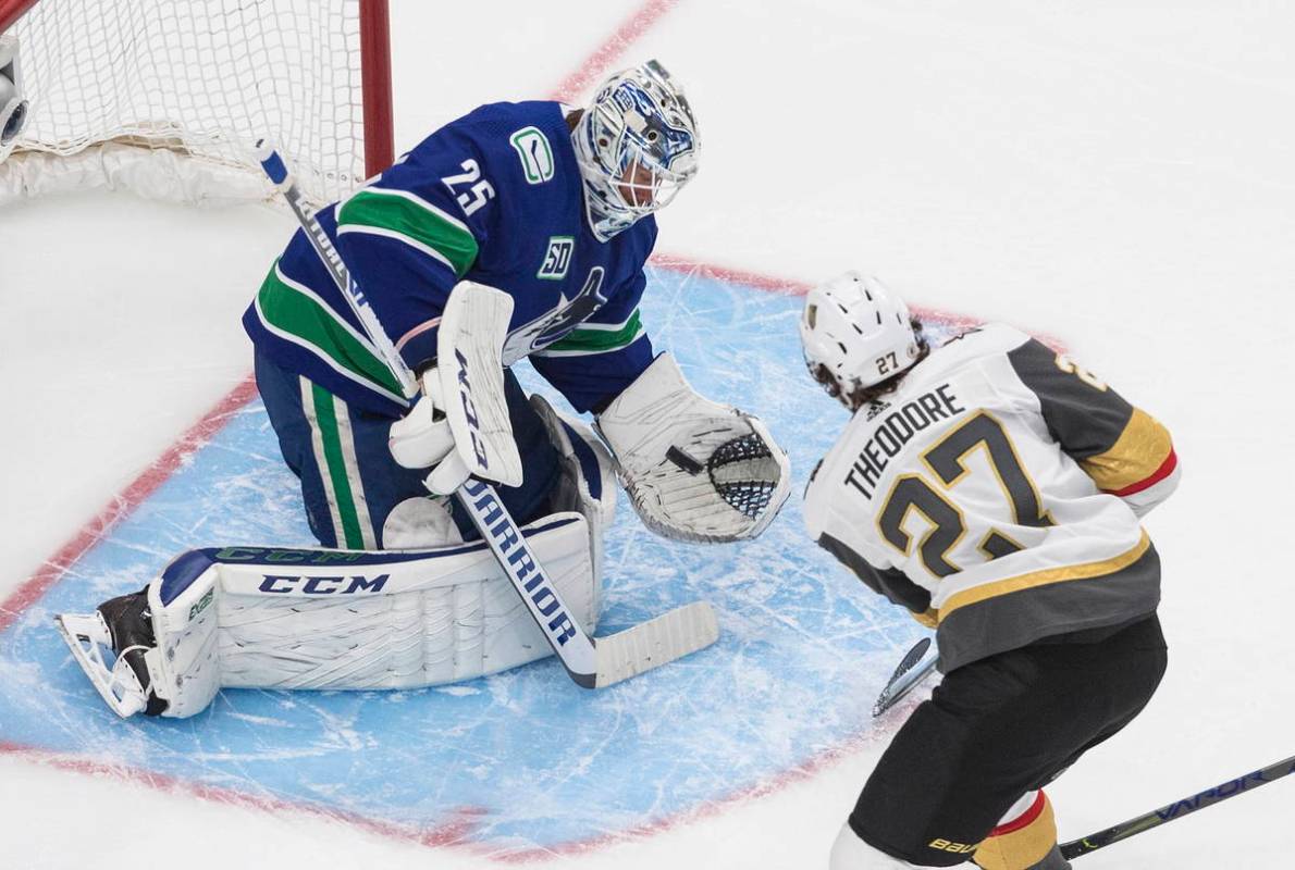 Vegas Golden Knights' Shea Theodore (27) is stopped by Vancouver Canucks goalie Jacob Markstrom ...