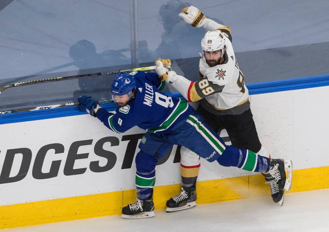 Vegas Golden Knights' Alex Tuch (89) checks Vancouver Canucks centre J.T. Miller (9) during the ...