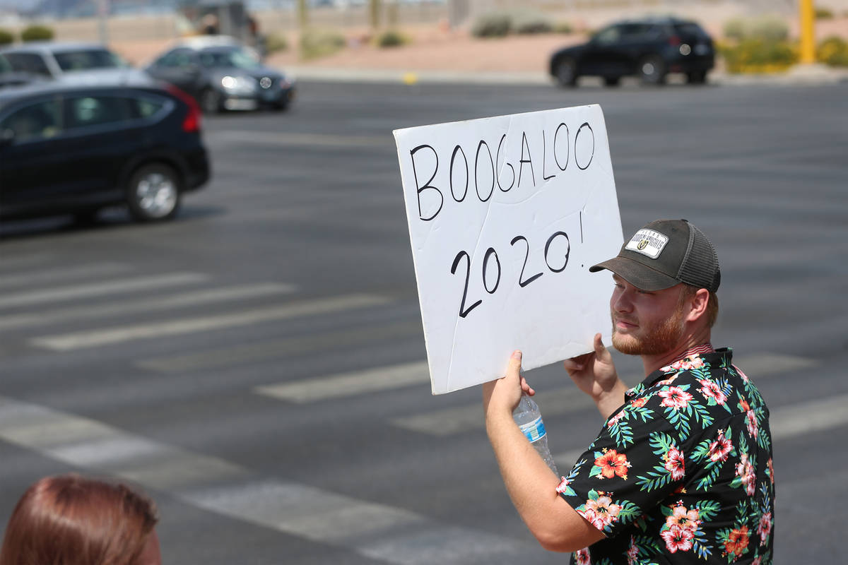 A man participating in a No Mask Nevada PAC rally displays his boogaloo sign at Sunset Park in ...