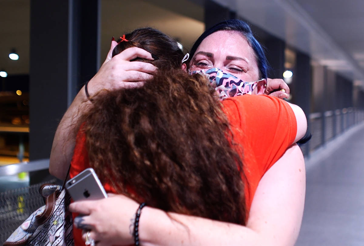 Alisha Burns hugs her sister Amanda Eubanks, whom she hasn't seen in 18 years, at McCarran Inte ...