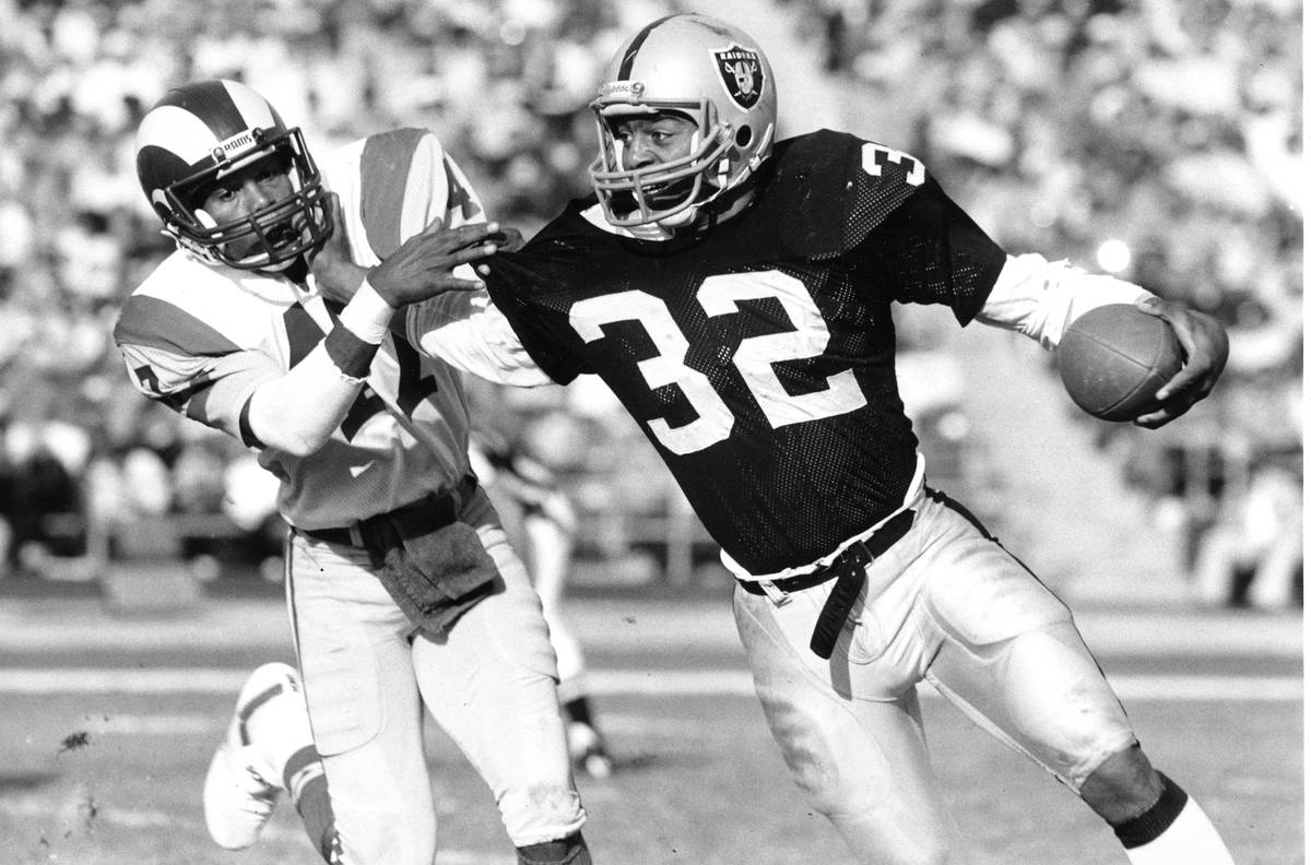 Los Angeles Raiders running back Marcus Allen (32) fends off Los Angeles Rams cornerback LeRoy ...