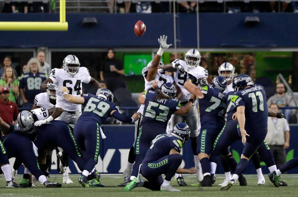 Seattle Seahawks kicker Sebastian Janikowski (11) kicks a point after following a touchdown aga ...