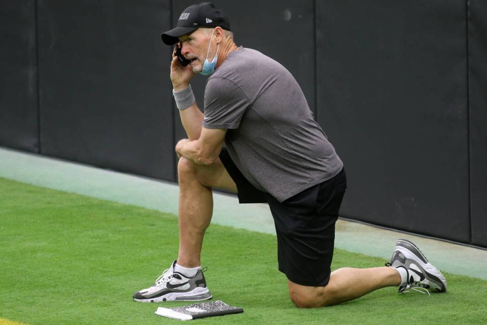 Las Vegas Raiders general manager Mike Mayock takes a phone call prior to a team practice at Al ...