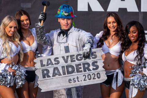 Painter Angel Ayala poses with a hammer between the Raiderettes during the official announcemen ...