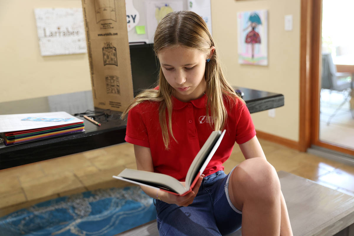 Lily Larrabee, 10, a student at Legacy Traditional School, reads a book after completing her sc ...