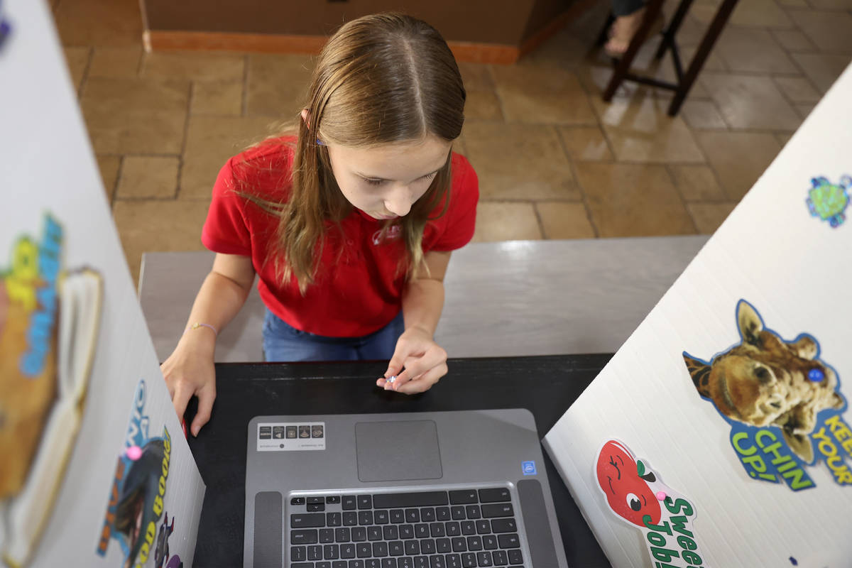 Lily Larrabee, 10, a student at Legacy Traditional School, works on her school work from her ho ...