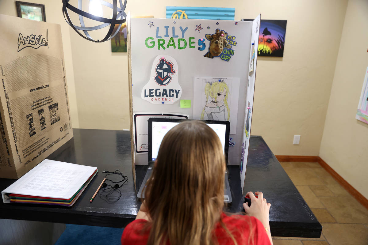 Lily Larrabee, 10, a student at Legacy Traditional School, works on her school work from her ho ...
