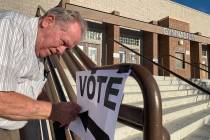 FILE--Poll worker Donald Somerville tapes up a sign for municipal elections at Bonanza High Sch ...