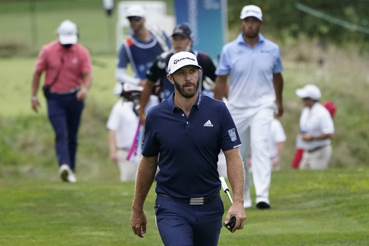 Dustin Johnson walks on the 13th fairway in front of Hideki Matsuyama, of Japan, top right, dur ...