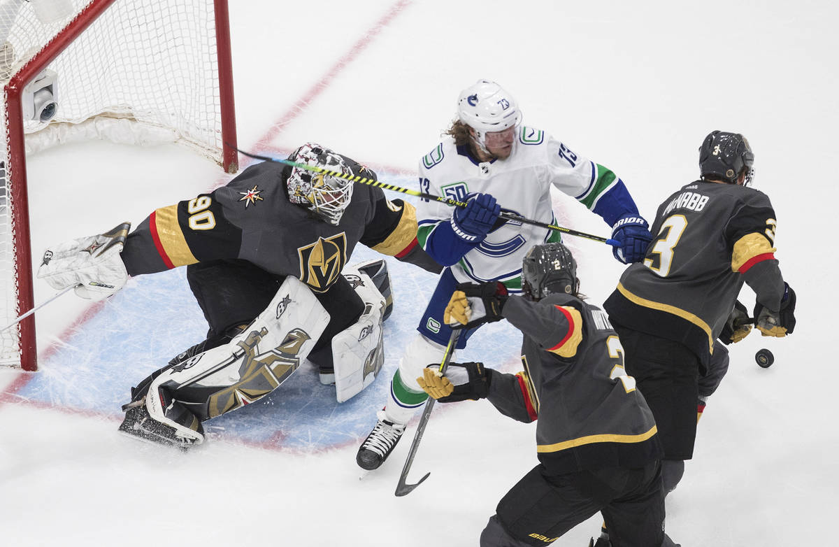 Vancouver Canucks' Tyler Toffoli (73) and Vegas Golden Knights' Zach Whitecloud (2) and Brayden ...