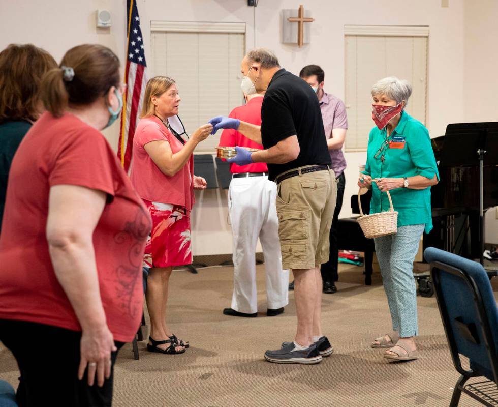 Minister Gregg Schiffbauer offers grape juice to Patty Duffey after a service at New Song Churc ...