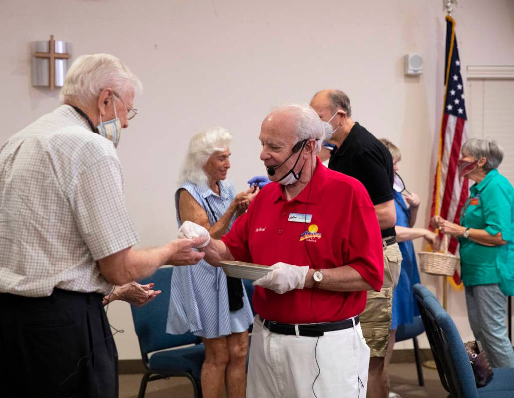 Pastor David Miller hands a Communion wafer to Brad Enerson after a socially distanced service ...