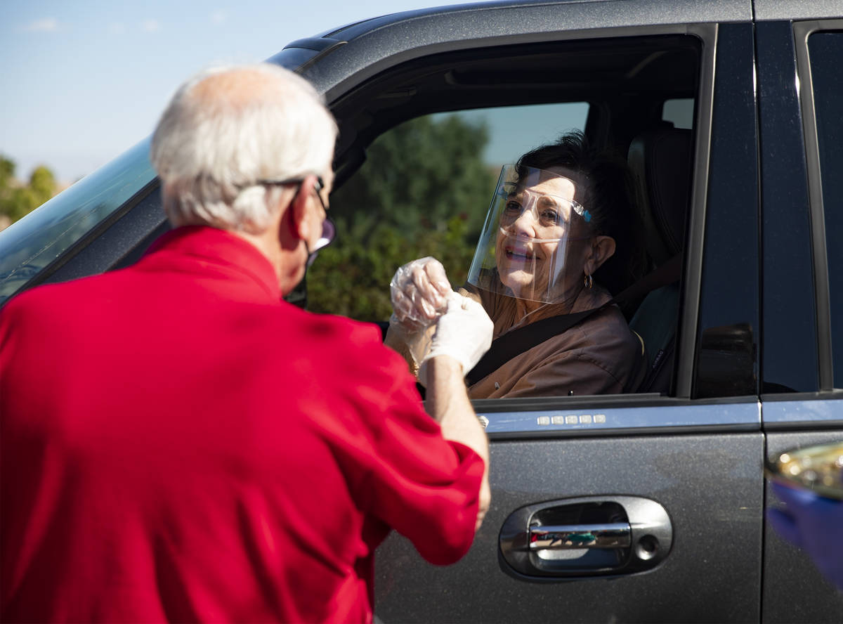 Pastor David Miller offers a Communion wafer to Shelle McIntyre during a Sunday morning drive- ...