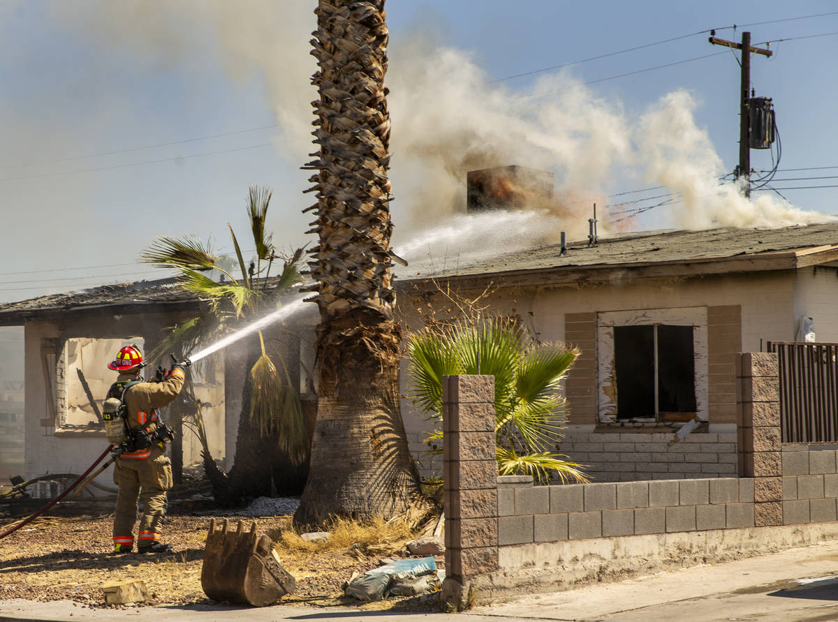 Fire continues to burn on the roof as Las Vegas firefighters battle a house fire on 5400 block ...
