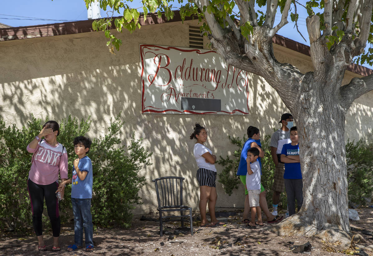 Nearby residents look on as Las Vegas firefighters battle a house fire on 5400 block of West Pe ...
