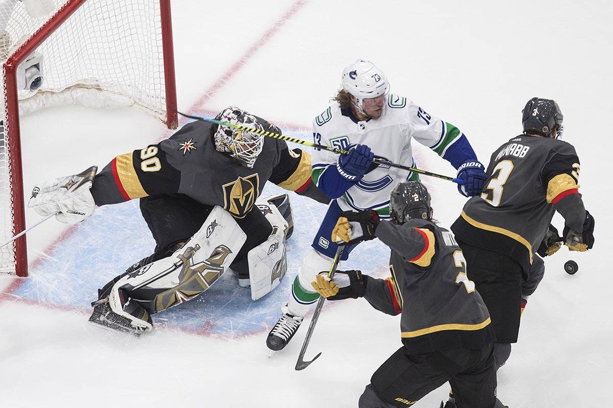 Vancouver Canucks' Tyler Toffoli (73) and Vegas Golden Knights' Zach Whitecloud (2) and Brayden ...