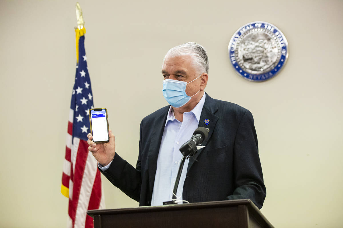 Gov. Steve Sisolak holds up a contact tracing app while giving an update on the state's COVID-1 ...