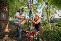 Volunteers Sue Ann Cornwell, left, and Alicia Mierke work on restoring individual memorial trel ...