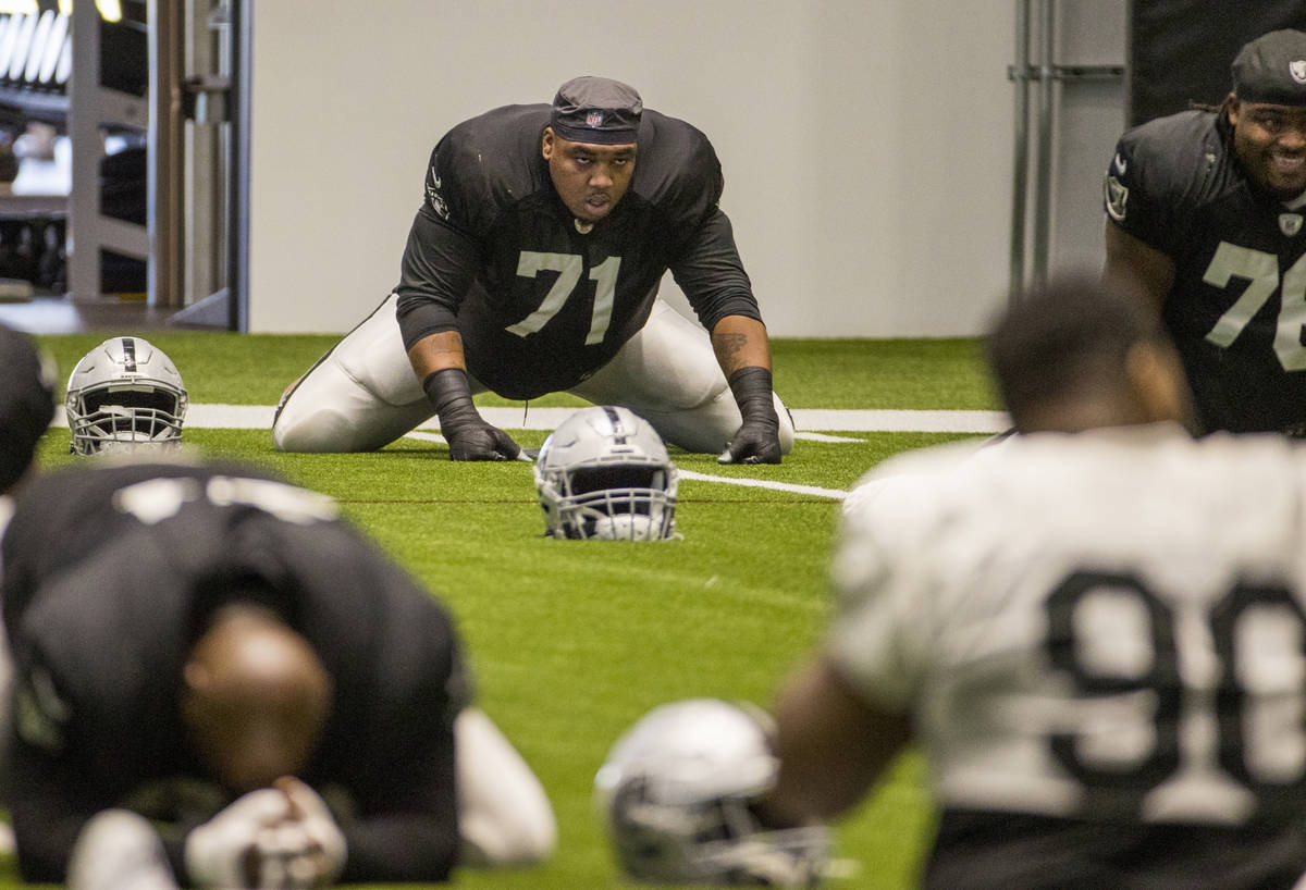 Las Vegas Raiders offensive tackle Denzelle Good (71) stretches with teammates during warm ups ...