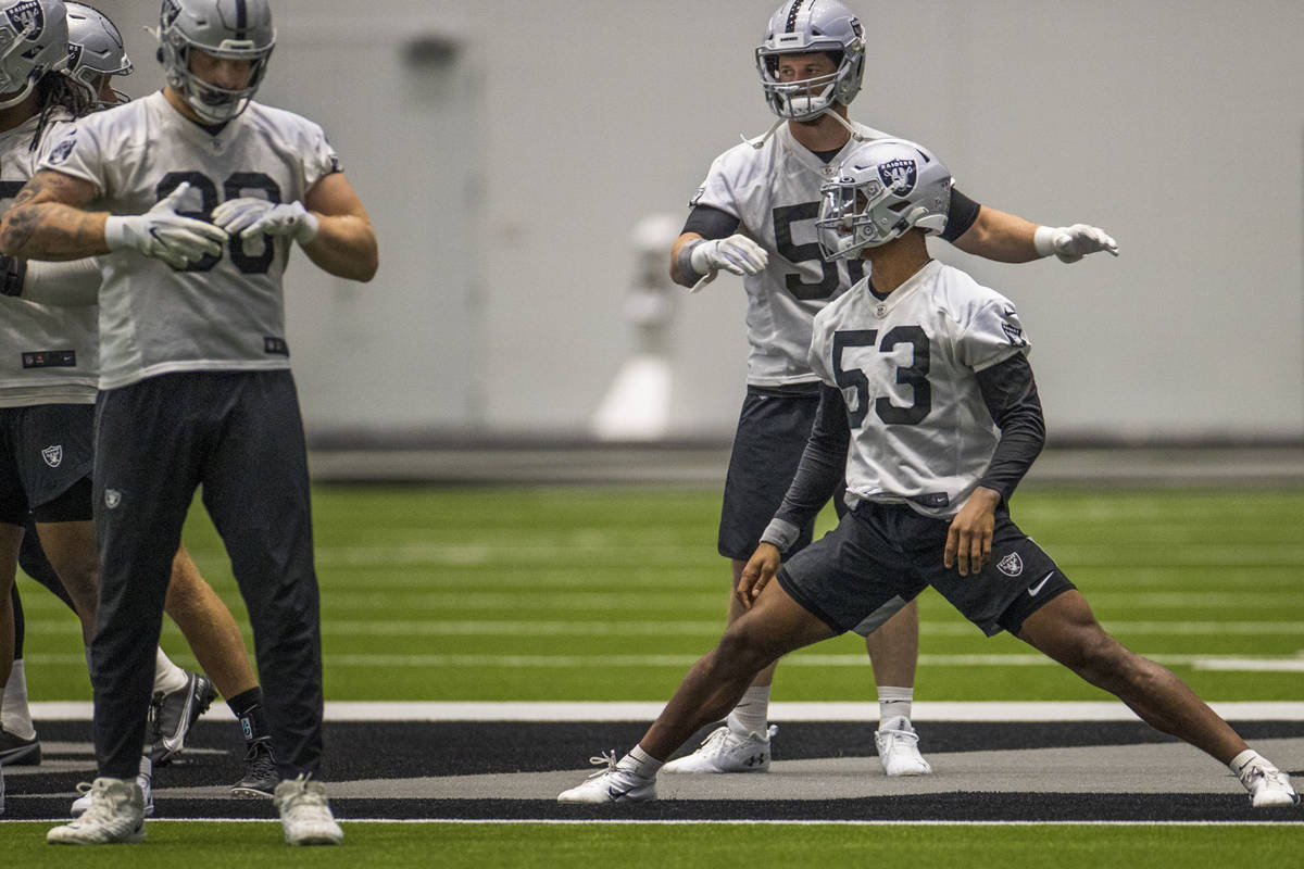 Las Vegas Raiders linebacker Javin White (53, right) stretches with teammates during warm ups a ...