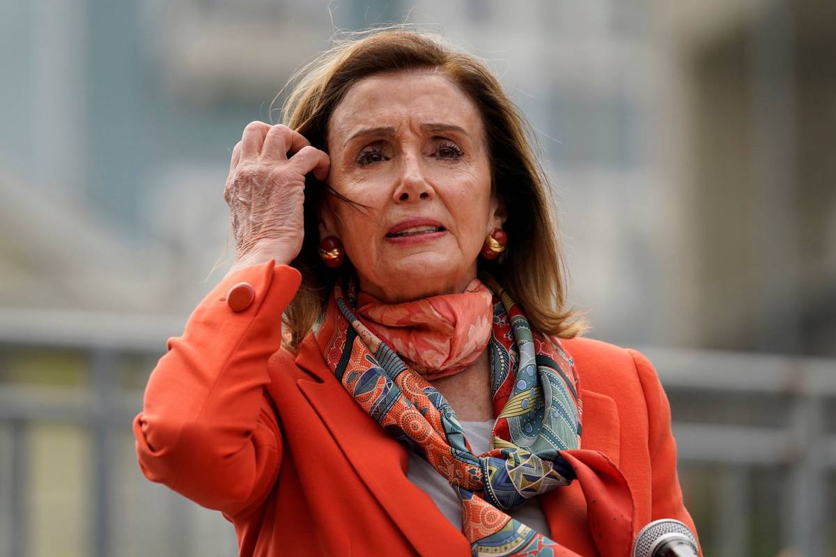 House Speaker Nancy Pelosi pulls back her hair while speaking about her visit to a hair salon d ...