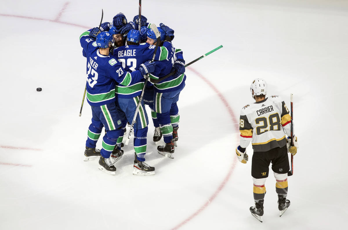 Vancouver Canucks players celebrate a goal as Vegas Golden Knights William Carrier (28) looks o ...