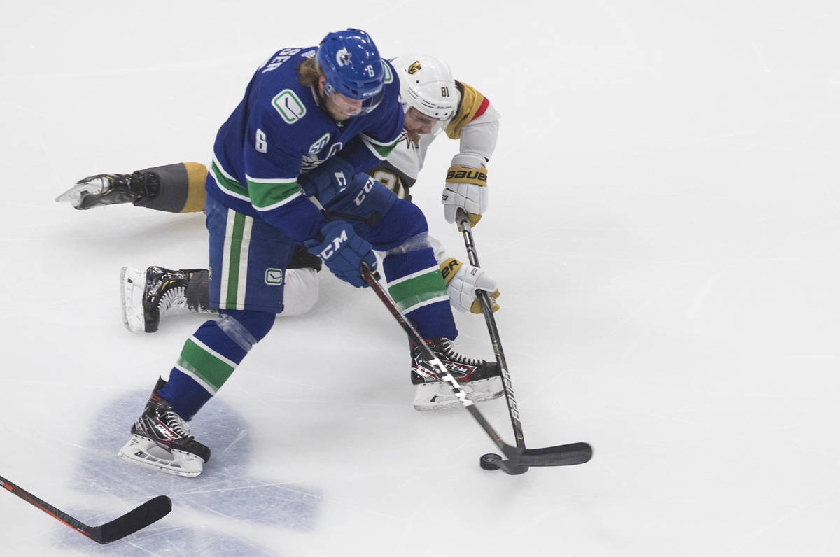 Vancouver Canucks' Brock Boeser (6) and Vegas Golden Knights' Jonathan Marchessault (81) vie fo ...
