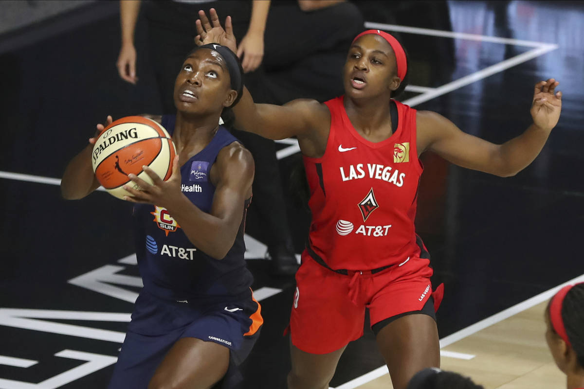 Connecticut Sun's Kaila Charles, left, drives past Las Vegas Aces' Jackie Young during the firs ...
