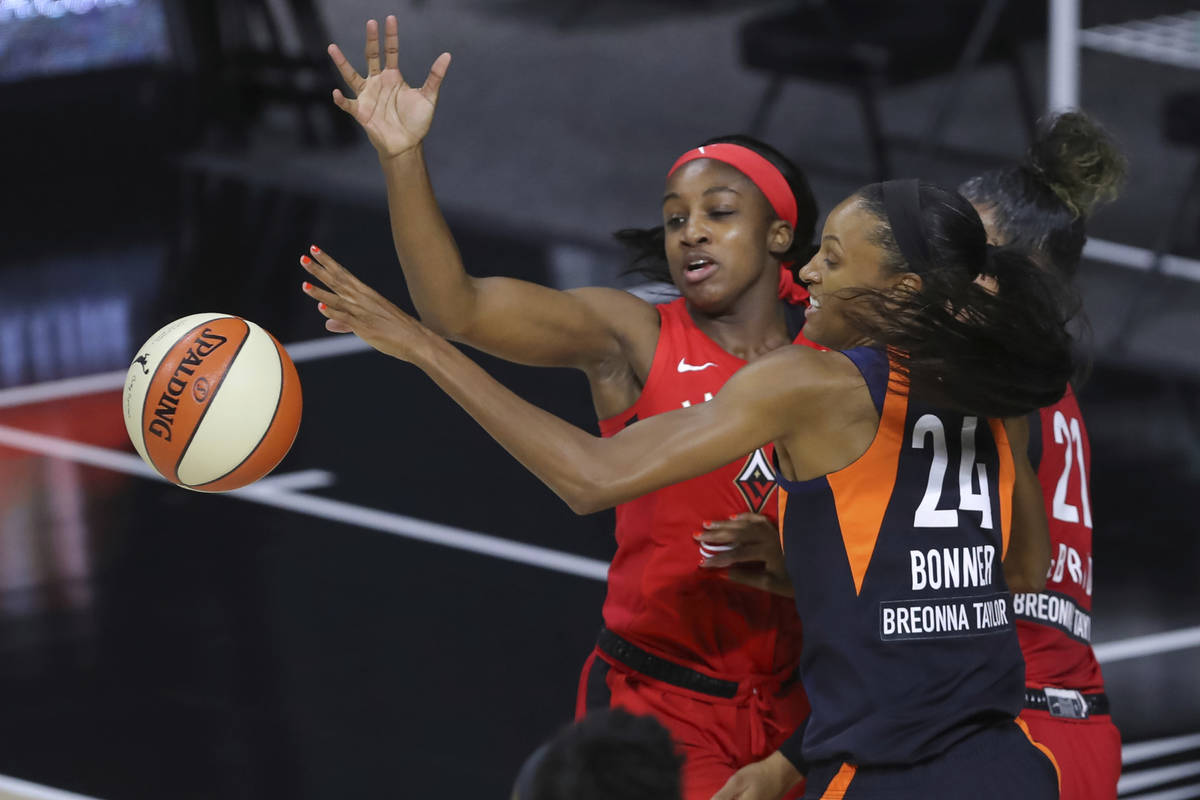 Connecticut Sun's DeWanna Bonner (24) and Las Vegas Aces' Jackie Young reach for the ball durin ...