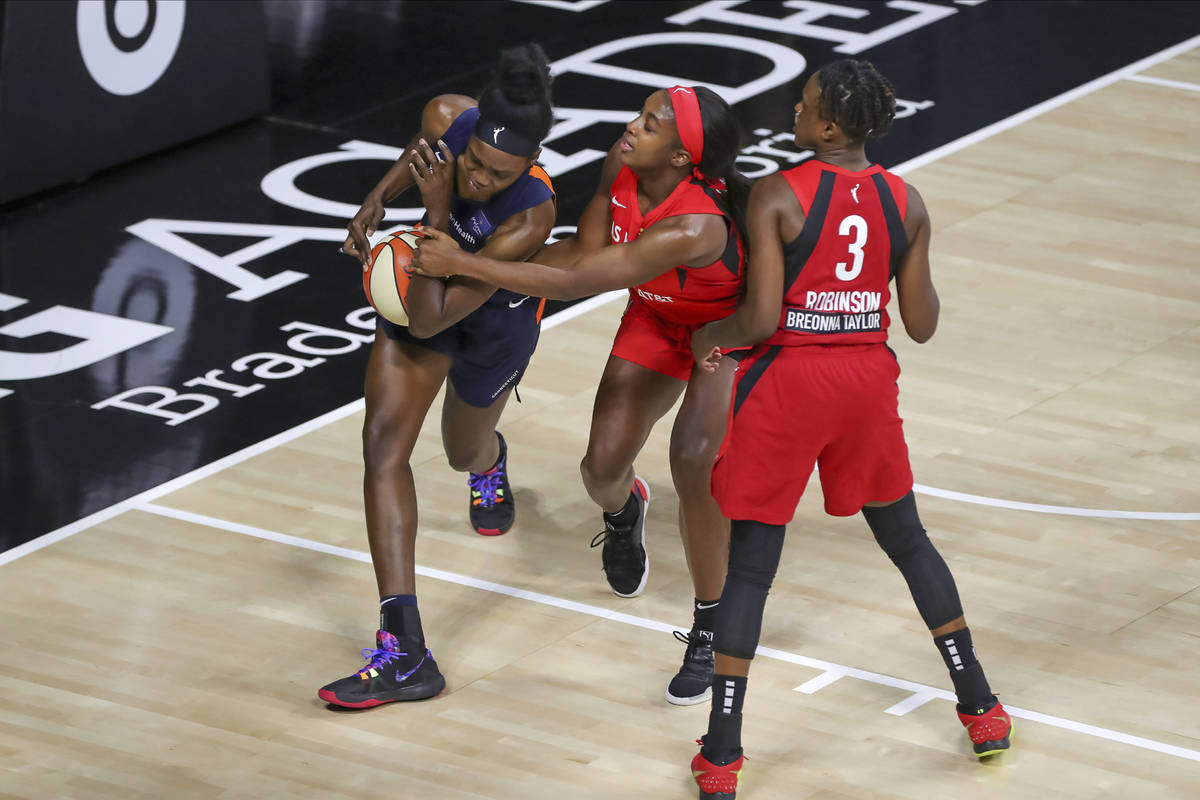 Connecticut Sun's Beatrice Mompremier, left, is stripped of the ball by Las Vegas Aces' Jackie ...