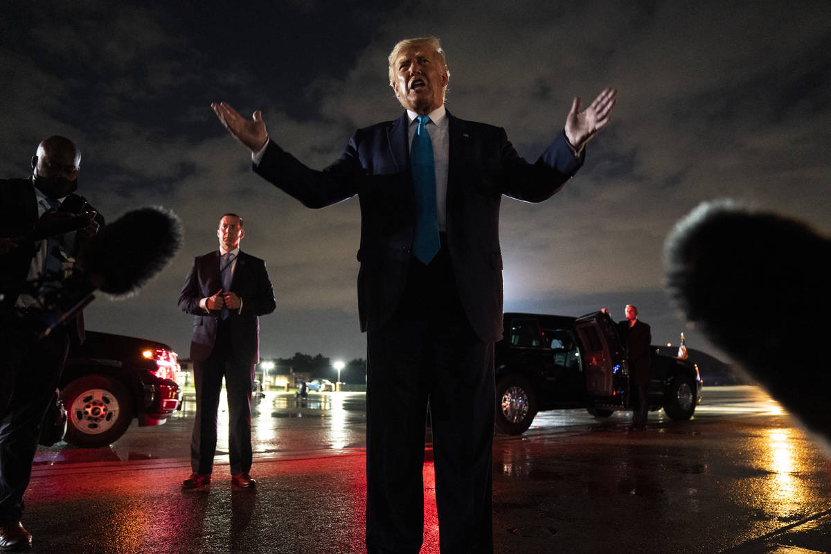 President Donald Trump talks with reporters at Andrews Air Force Base after attending a campaig ...