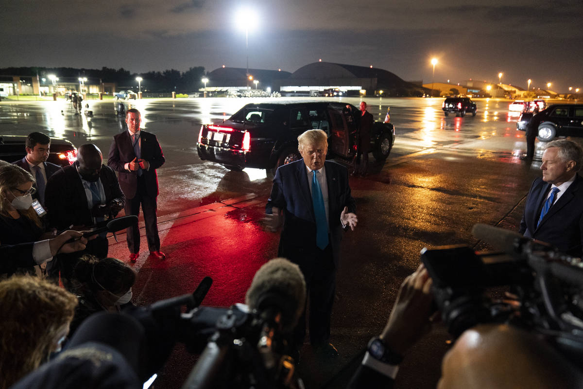 President Donald Trump talks with reporters at Andrews Air Force Base after attending a campaig ...