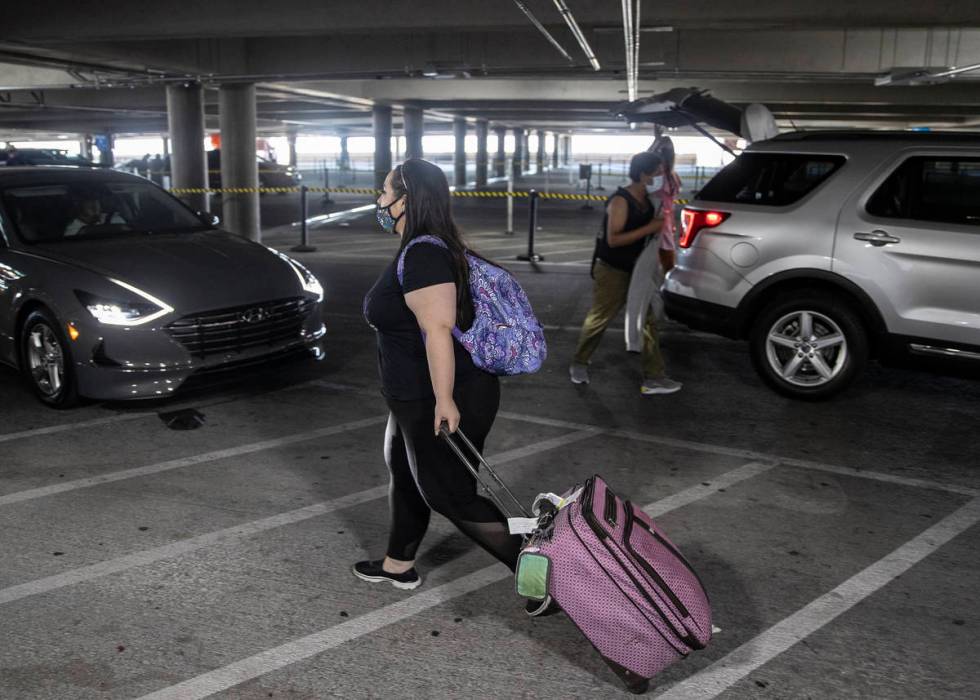 Arriving passengers walk to their ride share in Terminal 1 at McCarran International Airport on ...