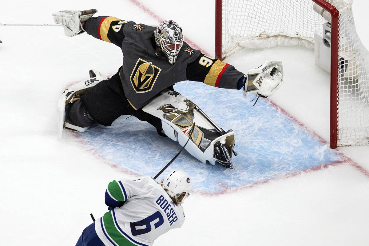 Vancouver Canucks' Brock Boeser (6) is stopped by Vegas Golden Knights goalie Robin Lehner (90) ...