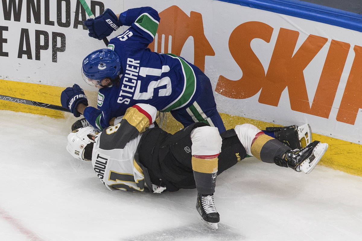 Vancouver Canucks' Troy Stecher (51) checks Vegas Golden Knights' Jonathan Marchessault (81) du ...