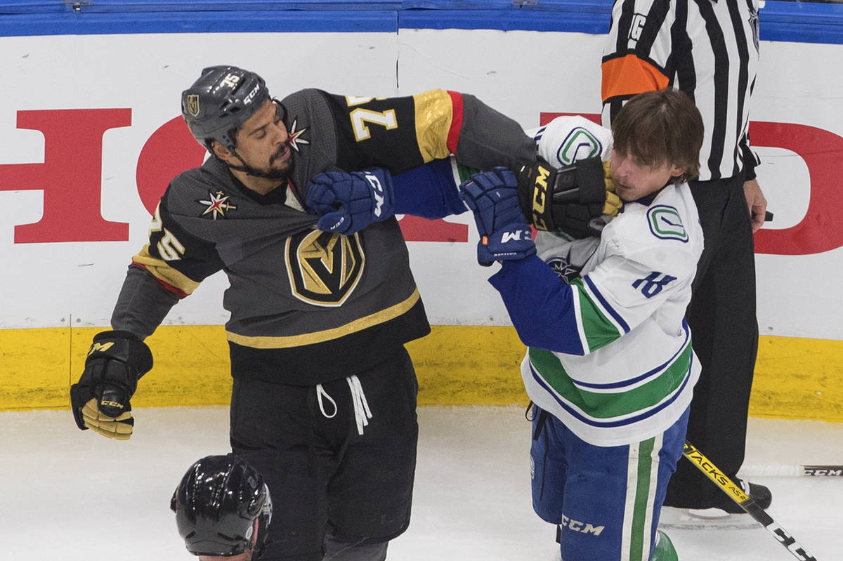 Vancouver Canucks' Jake Virtanen (18) and Vegas Golden Knights' Ryan Reaves (75) rough it up du ...