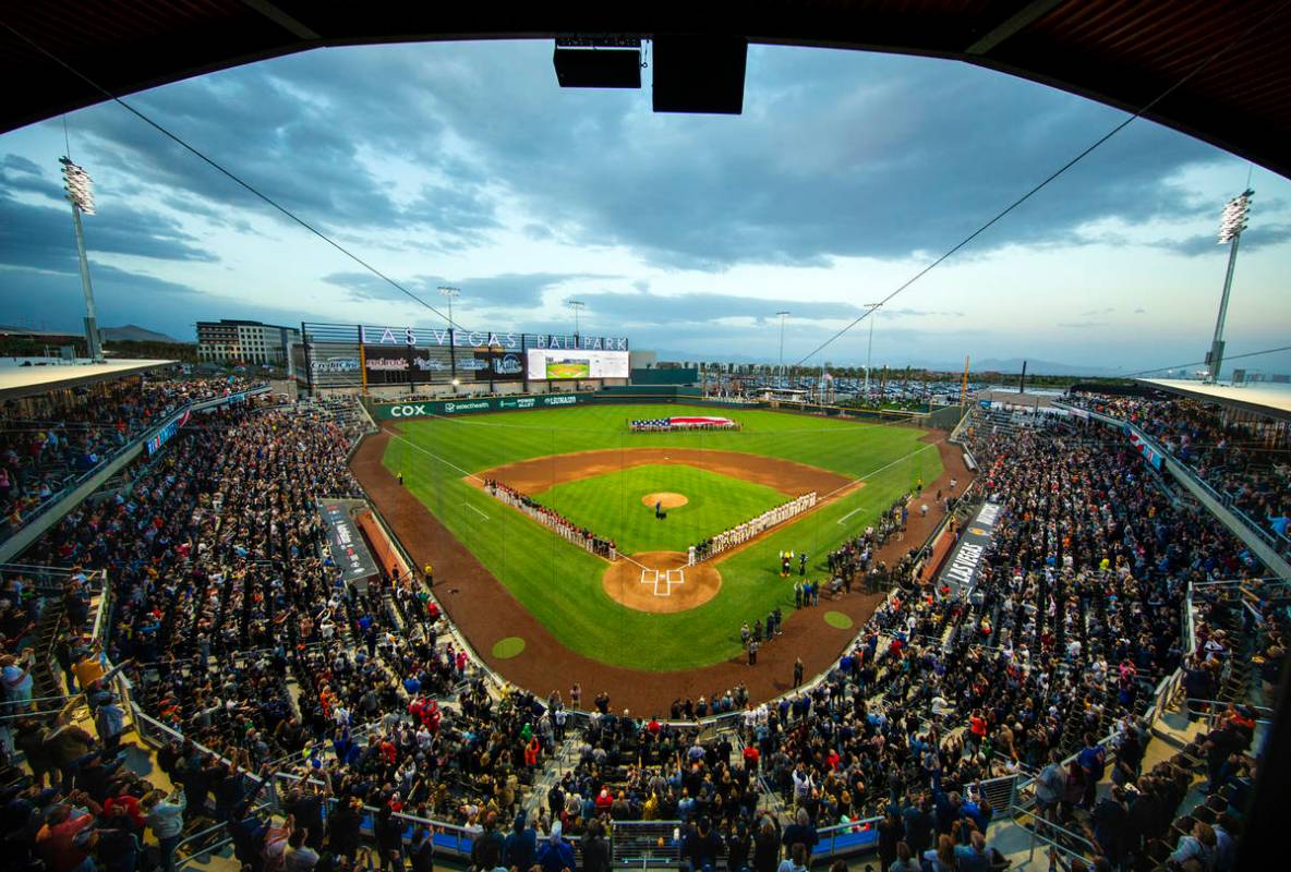 Four F-16 jets from Nellis Air Force Base fly over the ballpark with an American flag unfurled ...