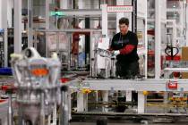 An employee assembles a drive unit at the Tesla Gigafactory, east of Reno. (Cathleen Allison/La ...