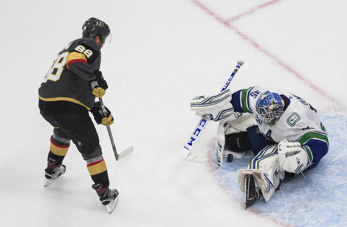 Vancouver Canucks goalie Thatcher Demko (35) makes a save on Vegas Golden Knights' Nate Schmidt ...