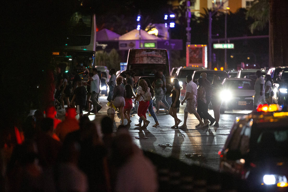 Visitors cross Las Vegas Boulevard on the Strip during Labor Day weekend on Saturday, Sept. 5, ...