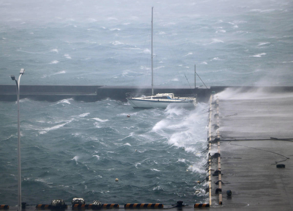 High waves pound a fishing port in Amami city, Kagoshima prefecture, southwestern Japan as a ty ...