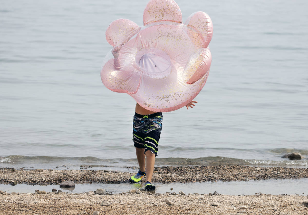 Aiden Murphy, 9, of Las Vegas carries his tube as he plays at Boulder beach in the Lake Mead Na ...