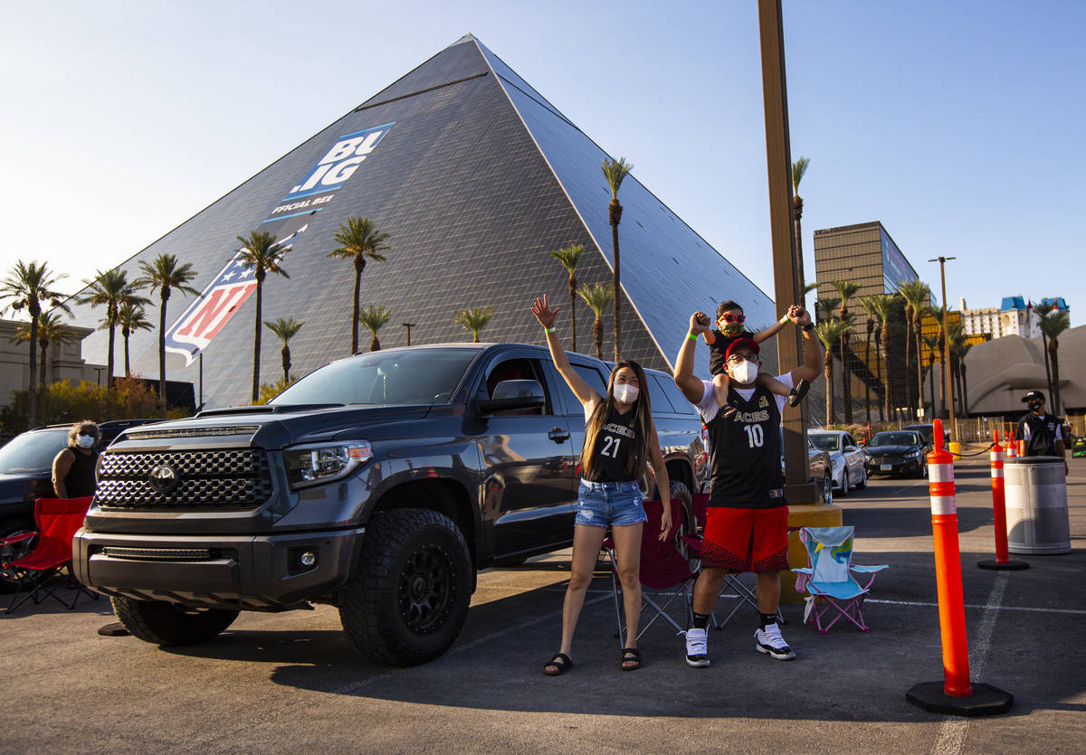 Las Vegas Aces fans Kris Gabriel, left, and Aubrey Gabriel, 3, held by Armand Reyes, cheer at t ...